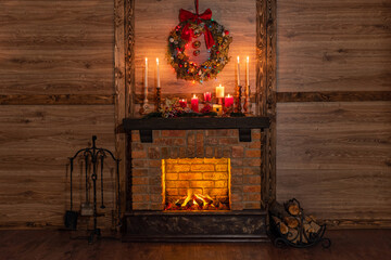 Many gift boxes near the Christmas fireplace in a festive interior of a Log Cabins with wooden walls. Mantelpiece with candles, Christmas wreath with bells