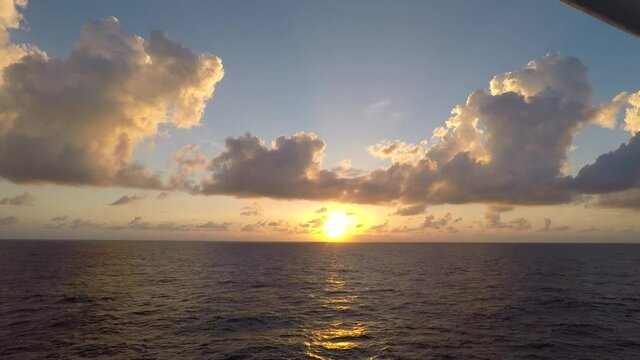 Timelapse of sunset in the sea. Waves on water surface and clouds passing on the blue sky.