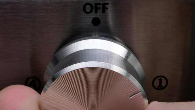 on and off adjustment. turn the device on and off with your fingers. electric stove in the kitchen detail. turning the electric stove on and off close-up