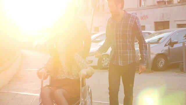 entertain a person with disability - slow motion on young woman with paraplegia having fun with her friends who quickly push her wheelchair
