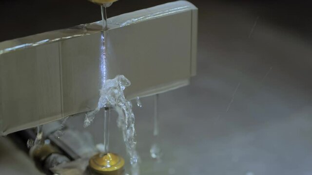 Slow motion: wire cutting machine working with metal workpiece with sparks at factory, exhibition, plant - close up. Metalworking, industrial, machining, manufacturing and equipment concept