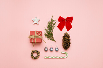 Christmas background with gift box and decorations on light pink. Preparation for holidays. Top view with copy space. Christmas composition. Flat lay.
