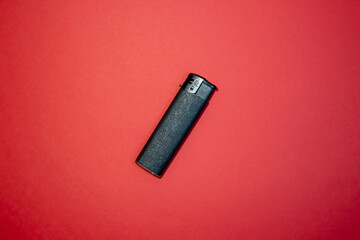Black lighter on a red background