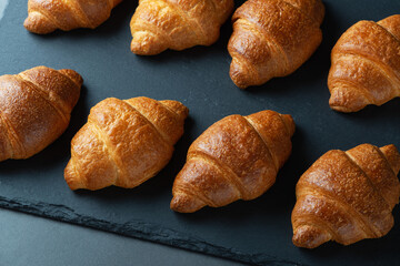 Group of croissant arranged in two rows and ready at the table for breakfast