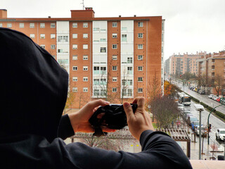 a man photographs someone from the window of an apartment