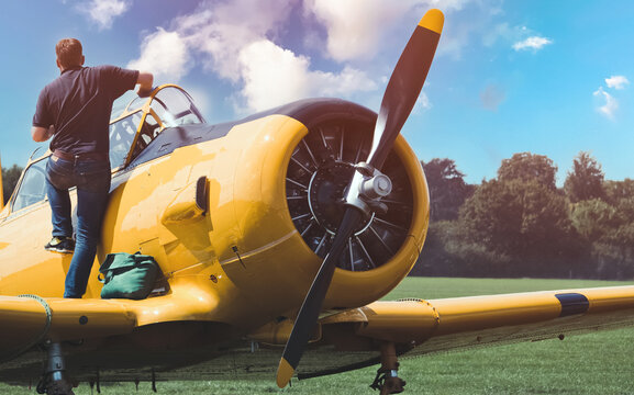 The wings and propellers of a small single-engine aircraft. Preparing an airplane by a person for flight.