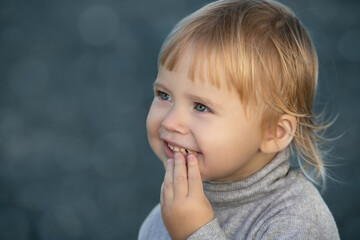 Child smiles face portrait on blue bokeh background