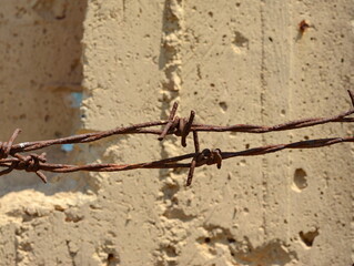 barbed wires against rough wall.