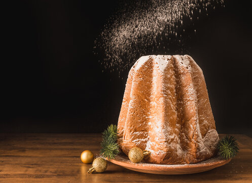 Pandoro traditional italian Christmas sweet cake bread with icing sugar copy space black background.