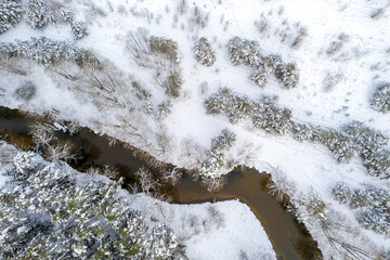Drone shot flying on forest and river in winter