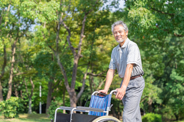 車椅子を押すシニア男性