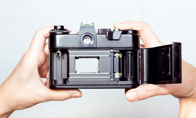 Illustrative retro soviet film camera in hands isolated on white background. Opened back side