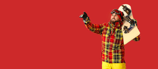 Male snowboarder showing something on color background with space for text