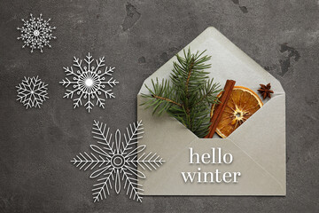 Envelope with fir tree branch and spices on grunge background. Hello winter