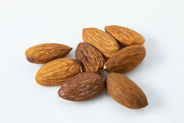 Serving of whole roasted almonds, ready to eat, isolated on white background