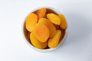 Top view of dried and seedless Turkish apricots in ceramic ramekin
