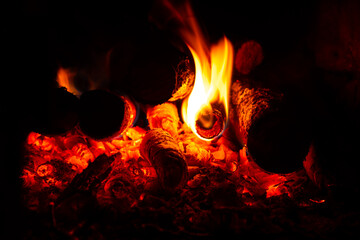 orange fire in the fireplace, burning logs and coals in the stove