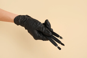 Female hand with manicure equipment on color background