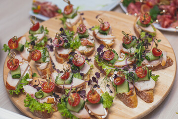 Catering table buffet dinner, beautifully decorated banquet with variety of different food snacks and appetizers on corporate birthday party event or wedding reception, canape, delicatessen setting