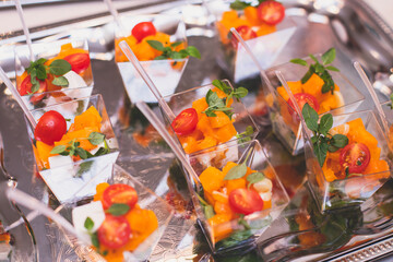 Catering table buffet dinner, beautifully decorated banquet with variety of different food snacks and appetizers on corporate birthday party event or wedding reception, canape, delicatessen setting