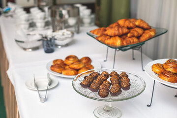 Set of coffee break in the hotel during conference meeting, with tea and coffee catering, decorated catering banquet table with variety of different pastry and bakery, with croissants and cookies