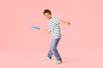 Funny little boy playing frisbee on color background