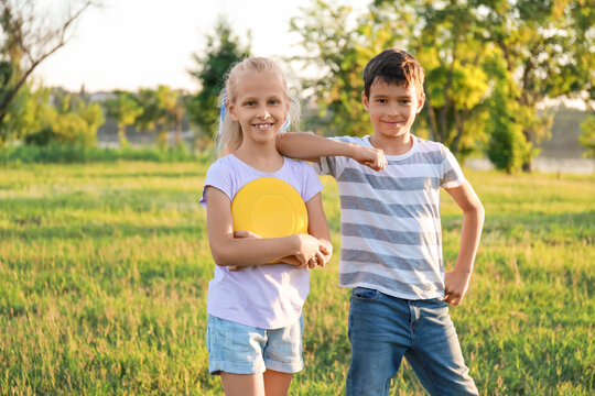 Funny little children with frisbee disk outdoors