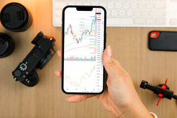 Financial stock market graph on the smartphone screen. Content creator environment with keyboard, camera and mic. Stock Exchange