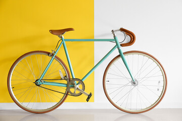 Stylish bicycle near yellow and white wall