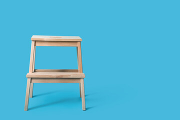Wooden step stool on blue background