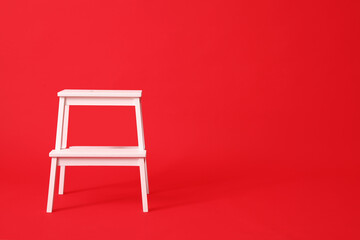 White step stool on red background