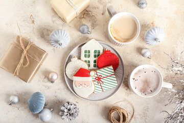 Plate with beautiful Christmas cookies and cups of tasty cocoa on light background