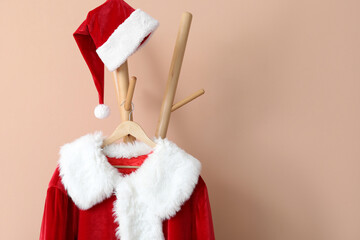 Santa Claus suit on hanger near color wall in hallway