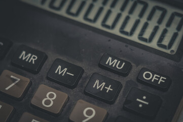 Close-up of an old dusty calculator. Electronic equipment for counting and calculations. Selective focus