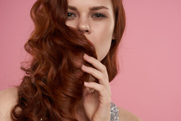 woman in a silver dress beautiful hairstyle bright makeup pink background