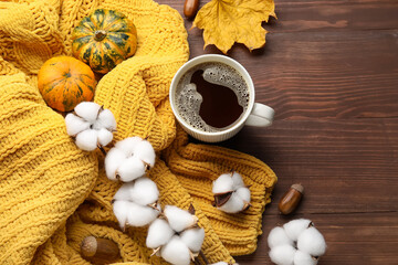 Cup of coffee, beautiful cotton flowers, sweater and autumn decor on wooden background