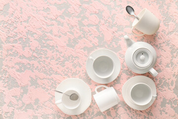 Set of stylish dinnerware on pink grunge background