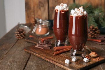 Glasses of tasty hot chocolate with marshmallows on wooden background