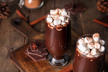Glasses of tasty hot chocolate with marshmallows on wooden background