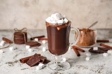 Glass cup of tasty hot chocolate with marshmallows on light background