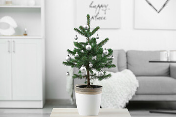 Beautiful decorated Christmas tree in pot on table indoors