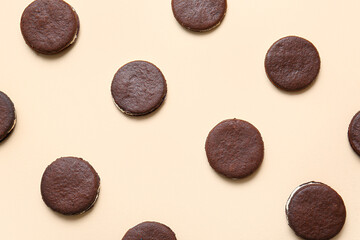 Tasty chocolate cookies with cream on beige background