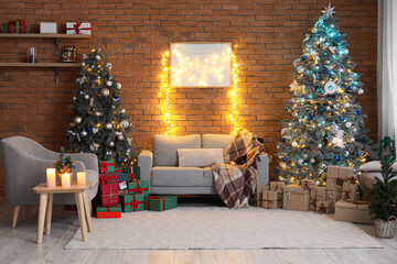 Interior of festive living room with Christmas trees, grey sofa and armchair