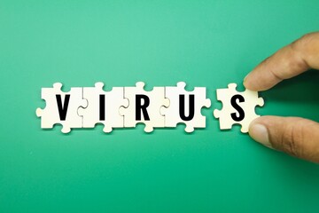 hand holding a puzzle with the word virus