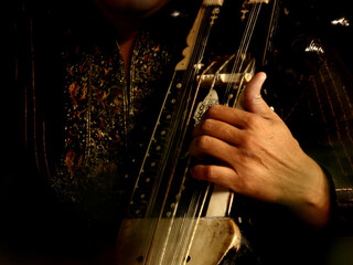 Close up of hand playing Indian musical instrument Sarangi.
