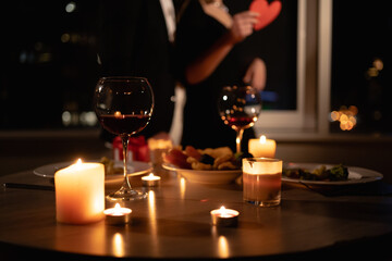 romantic dinner setting, red wine in glasses and candles, date for two, Valentine's Day evening