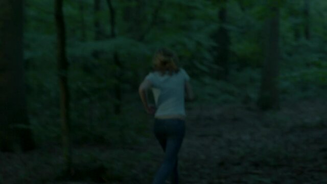 Scared woman running through forest