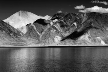 Reflection of Mountains on Pangong tso - Lake It is huge lake in Ladakh, It is 134 km long and extends from India to Tibet. Leh, Ladakh, Jammu and Kashmir, India. Black and white image.