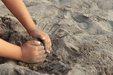 manos niño arena