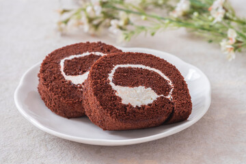 Chocolate roll cake on white plate